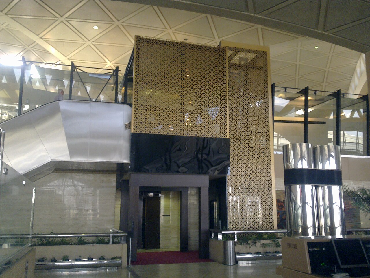 Vestíbulo de una terminal del aeropuerto internacional Rey Jalid de Riad, con una escalera y una estructura calada dorada (imagen de archivo de 2012)