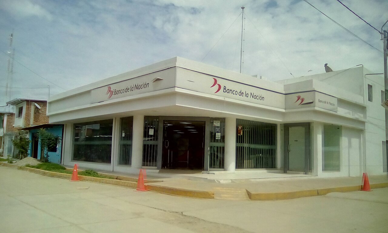 Fachada de una agencia del Banco de la Nación en una esquina de una calle, con conos naranjas en la acera