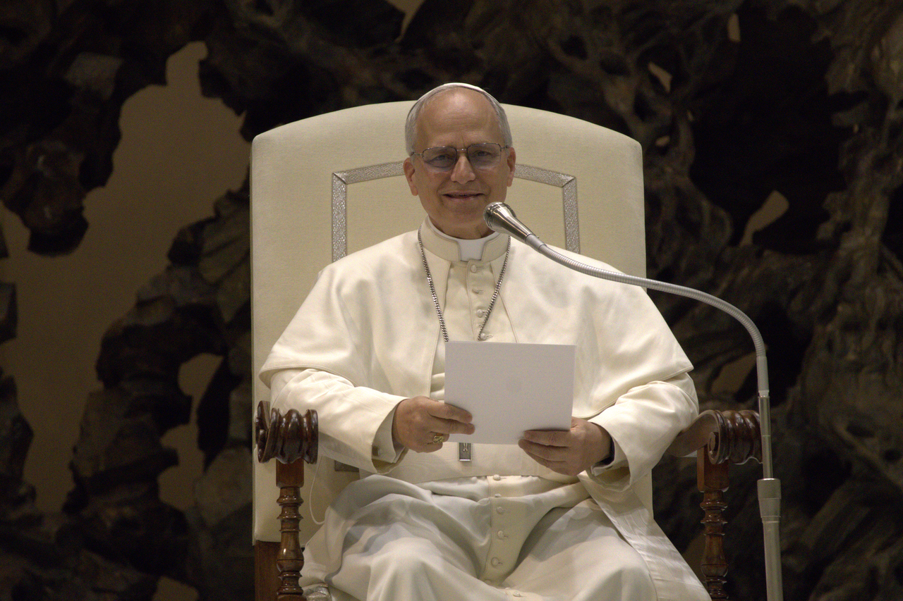 El papa León XIV, sentado y sonriente, con una hoja en las manos durante una audiencia con los medios de comunicación en mayo de 2025 (imagen de archivo)