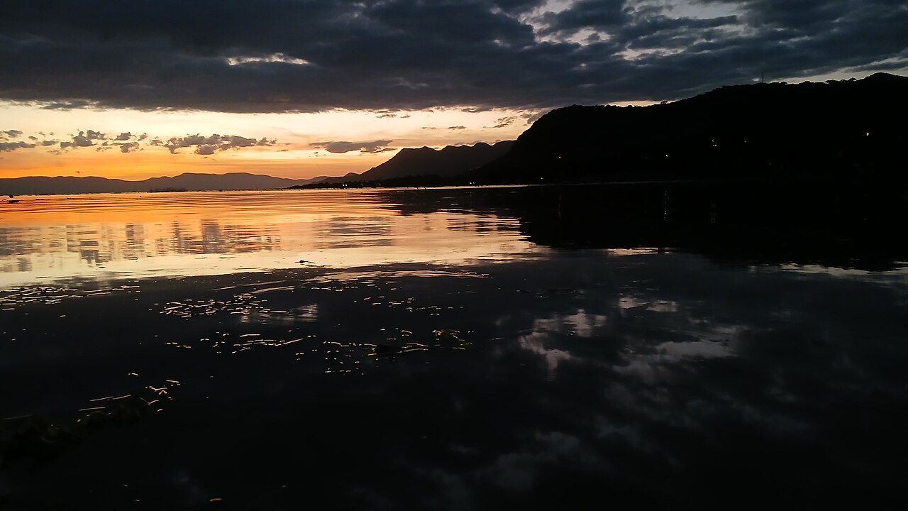 Atardecer sobre el lago de Chapala, en Jalisco, con montañas al fondo y el agua en calma