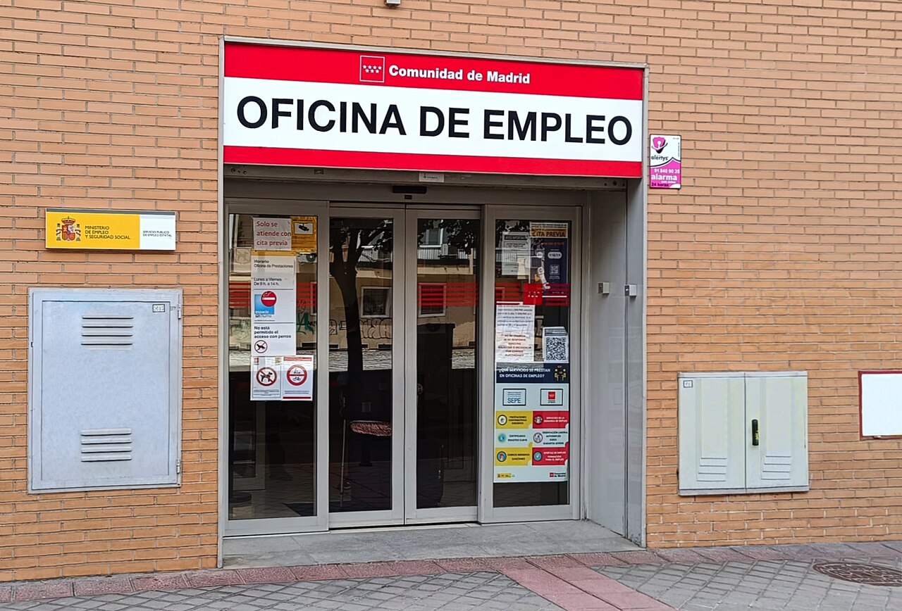 Puerta de acceso a una oficina de empleo conjunta de la Comunidad de Madrid y el Servicio Público de Empleo Estatal (SEPE) en Madrid, con el cartel 'Oficina de Empleo' y el logotipo del SEPE en el cristal