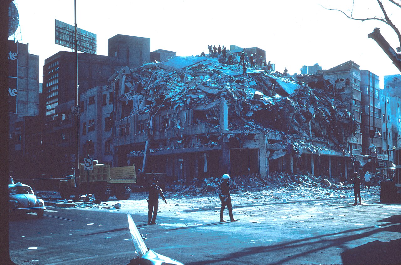 Edificio de ocho plantas con los pisos superiores derrumbados tras el terremoto de Ciudad de México de 1985, con rescatistas sobre los escombros