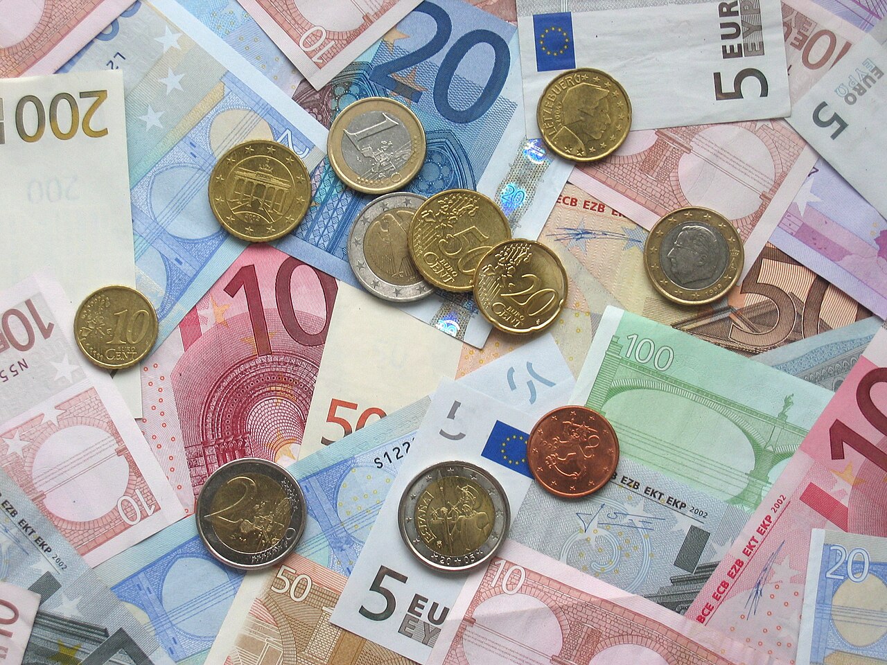 Billetes y monedas de euro de distintas denominaciones sobre una superficie