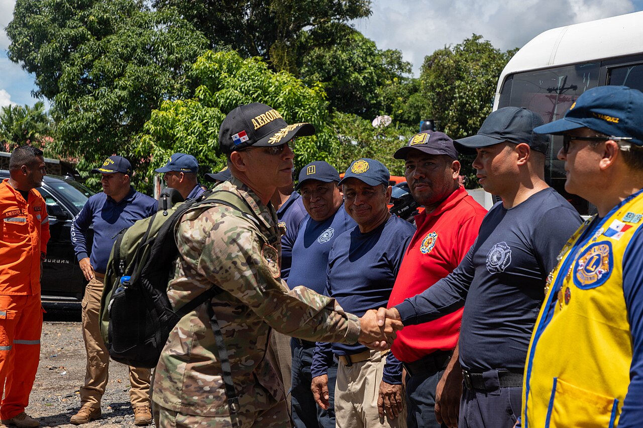 Un comandante del Servicio Nacional Aeronaval de Panamá estrecha la mano de bomberos durante las labores de ayuda en Soná, provincia de Veraguas, tras el terremoto