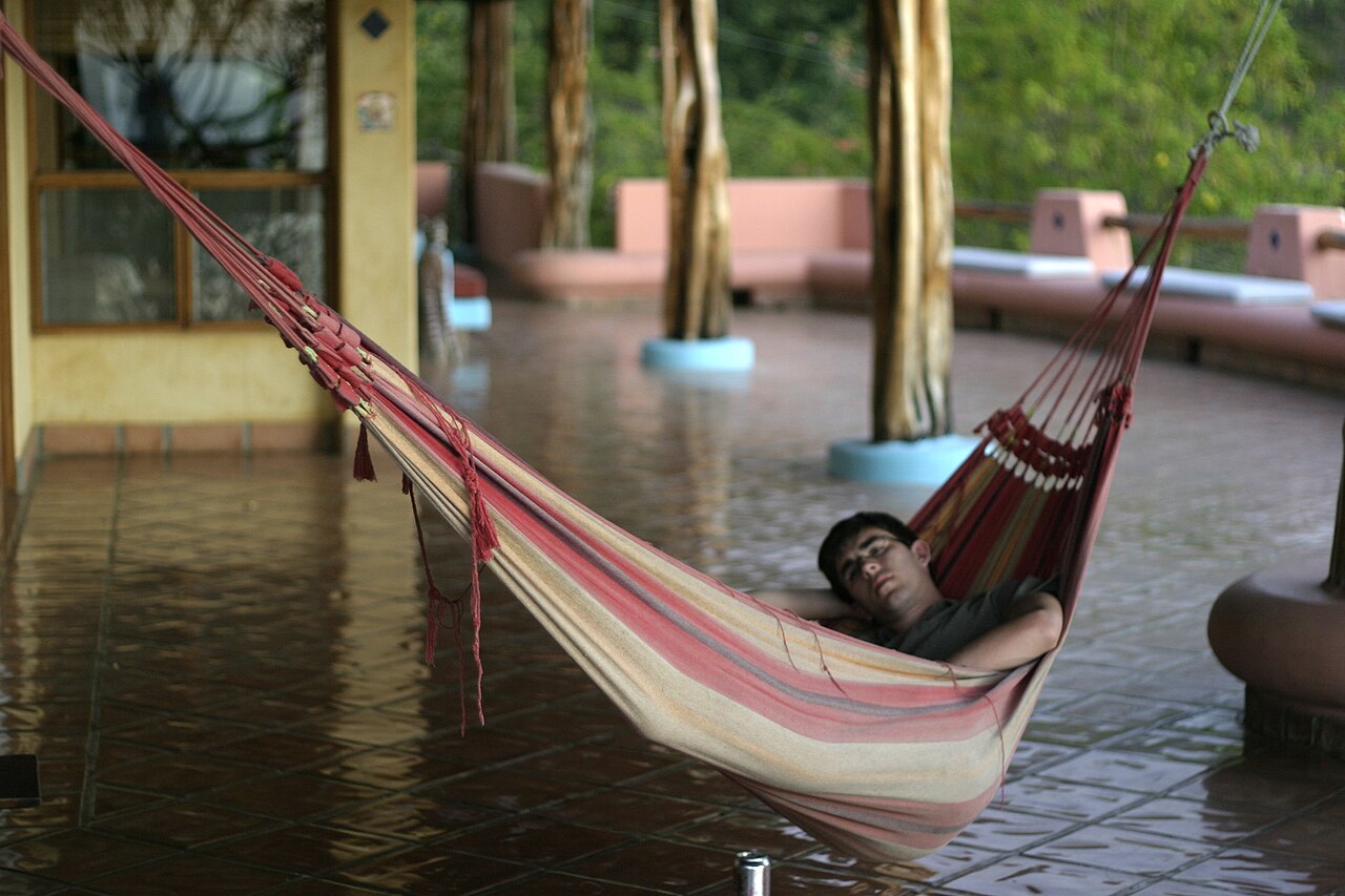 Un hombre duerme la siesta en una hamaca durante el día