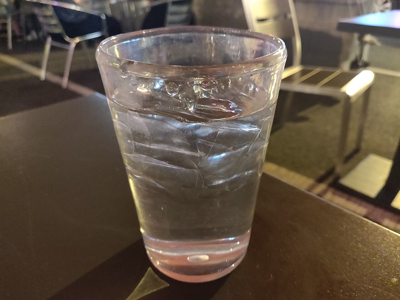 Un vaso de agua con hielo sobre una mesa