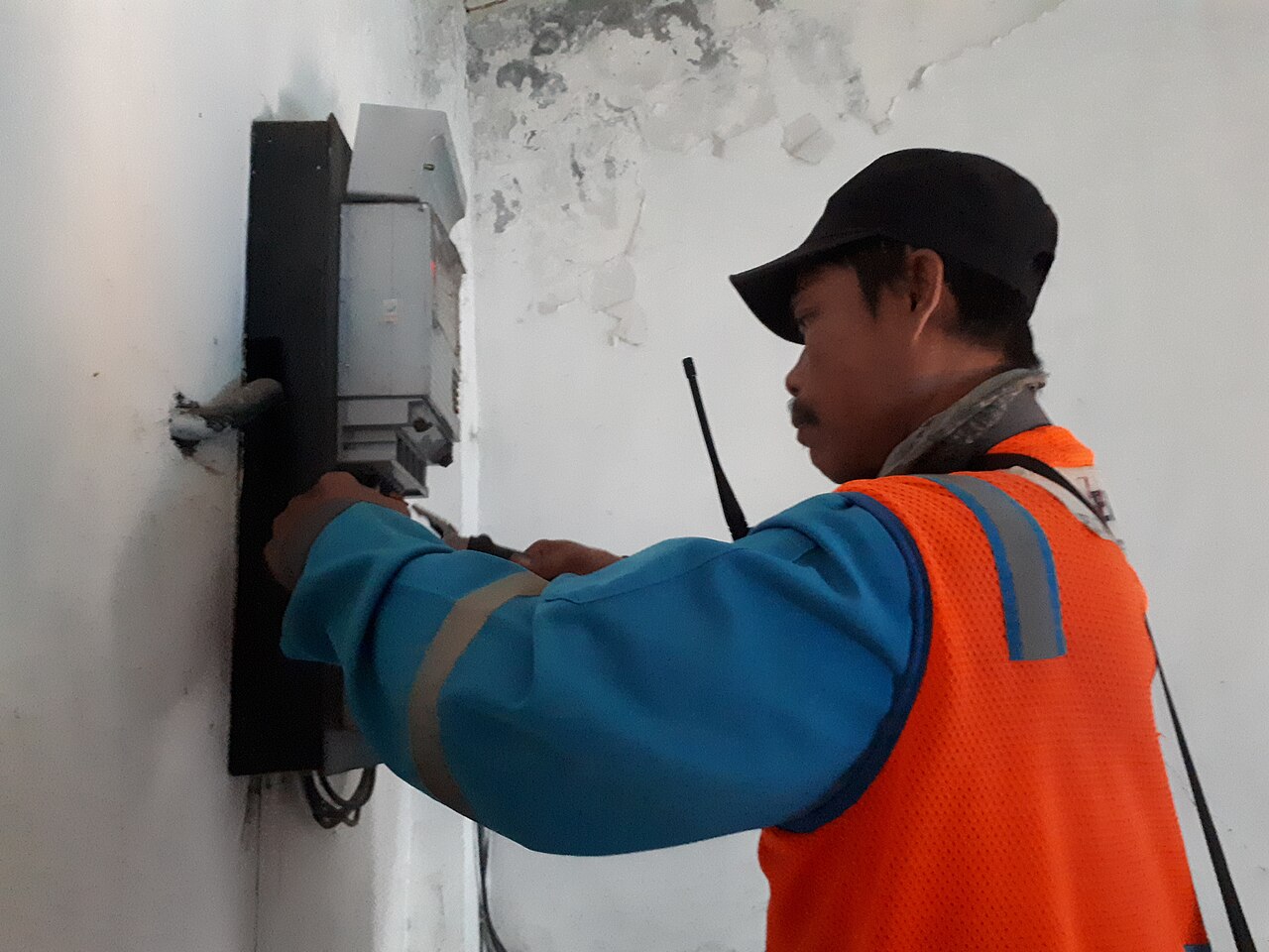 Técnicos revisando un contador eléctrico en una vivienda